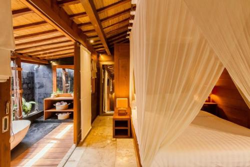 a bedroom with a bed with a curtain at Villa Lucky in Canggu