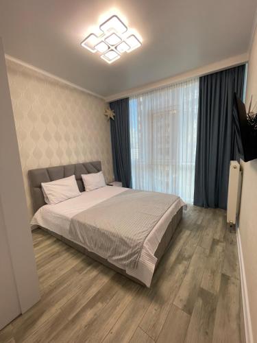 a bedroom with a large bed and a large window at Nika apartment in Odesa