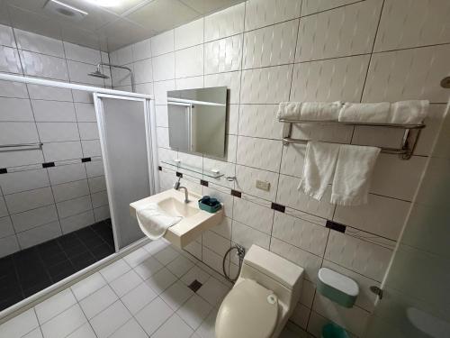 ein weißes Badezimmer mit Toilette und Waschbecken in der Unterkunft 回家浪 in Altstadt von Hengchun