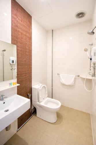 a white bathroom with a toilet and a sink at KARANG TIMUR Hotel in Kuantan
