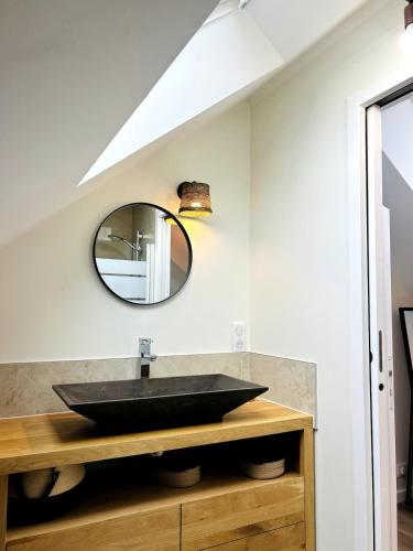 a bathroom with a black sink and a mirror at Atelier Cancalais - Hypercentre, maison de ville in Cancale