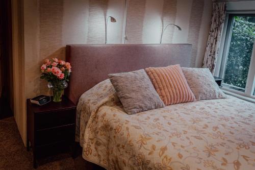 a bedroom with a bed with a vase of flowers at Vledderstee in Vledderveen