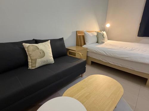 ein Wohnzimmer mit Sofa und Bett in der Unterkunft 回家浪 in Altstadt von Hengchun