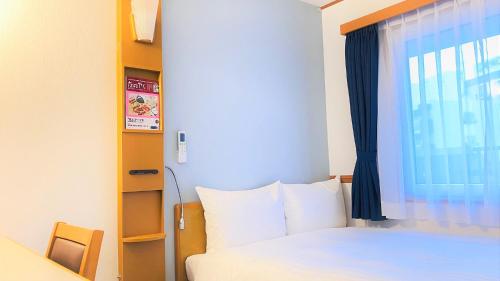 a bedroom with a bed and a window at Toyoko Inn Fukuoka Tenjin in Fukuoka