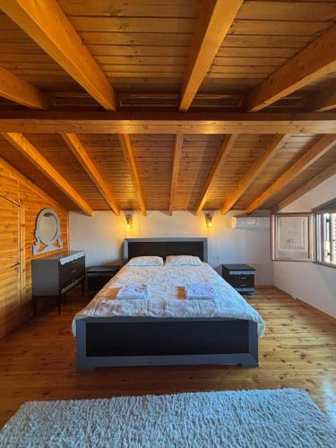 a large bedroom with a large bed with a wooden ceiling at Gem Guest House in Lazarat