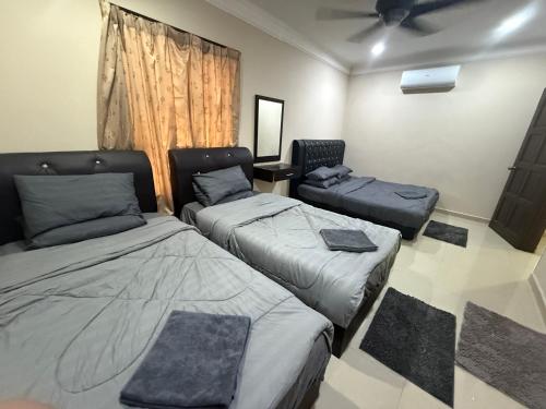 a room with two beds and a couch at Megrram Homestay Ipoh-entire bungalow for 32 pax in Ipoh