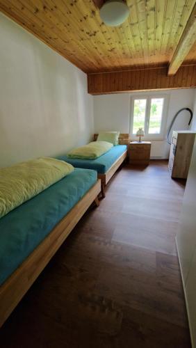 a bedroom with two beds and a wooden ceiling at Ferienwohnung Tulipana in Müstair