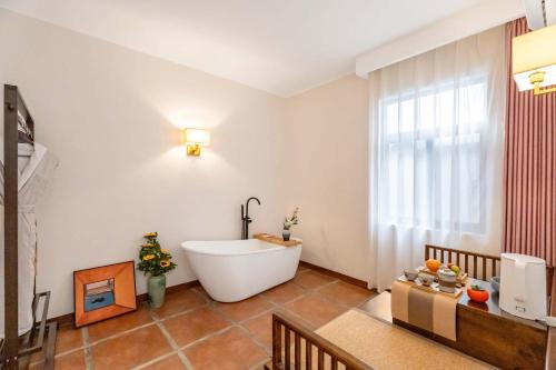 a bathroom with a bath tub and a window at 赛家花园酒店SAI JIA Garden HOTEL in Dali Ancient Town