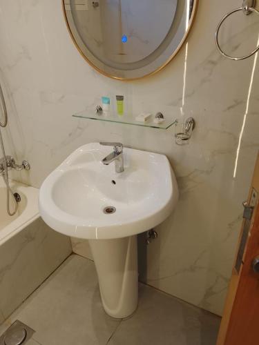 a bathroom with a sink and a mirror at Coral Bay Suite Hotel in Khor Fakkan