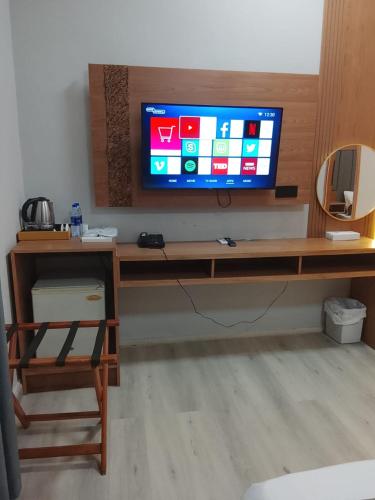 a living room with a television on a wooden table at Coral Bay Suite Hotel in Khor Fakkan