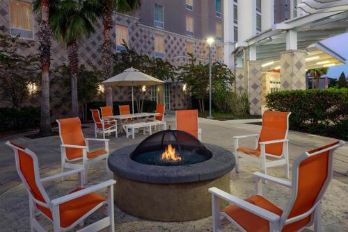 a fire pit with chairs and a table with an umbrella at Hampton Inn & Suites Tampa Airport Avion Park Westshore in Tampa