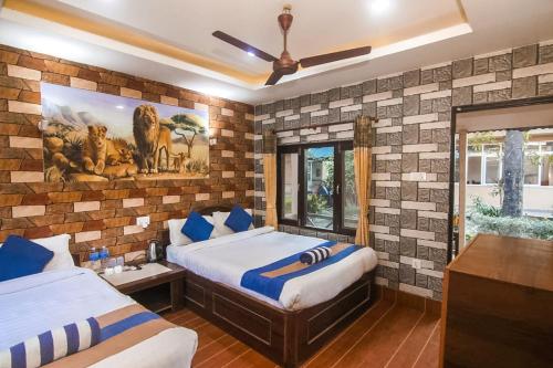 a bedroom with two beds and a mural of lions at Chitwan Forest Resort with swimming pool , Chitwan National Park in Sauraha