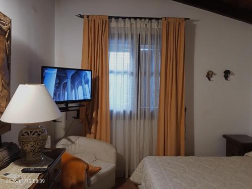a bedroom with a bed and a television and a lamp at Villa Amalia - mansarda B&B in Cinisi
