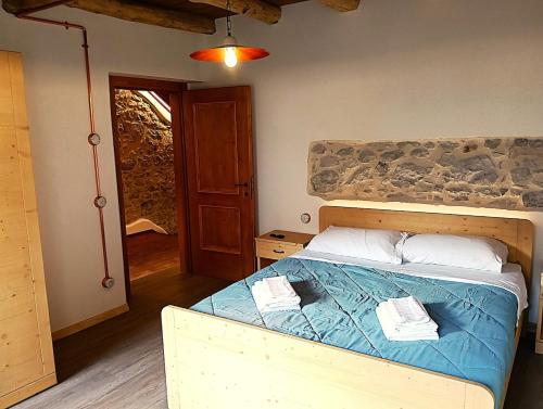 a bedroom with a bed with a blue comforter at La Casa dei Nonni in Caralte