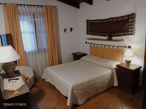 a bedroom with a bed and a chair and a window at Villa Amalia - mansarda B&B in Cinisi