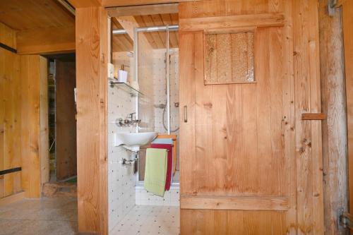 a bathroom with a sink and a wooden door at UNSER VORSÄSS - Klausberg in Schwarzenberg