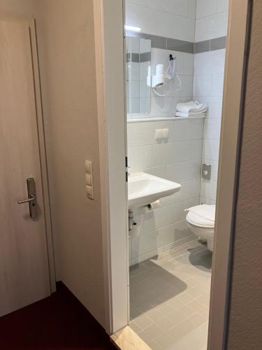 a bathroom with a sink and a toilet at Hotel Restaurant Elbebrücke in Oranienbaum-Wörlitz