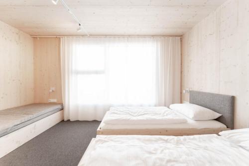 ein Schlafzimmer mit zwei Betten und einem Fenster in der Unterkunft Karlingerhaus Hotel Hostel Home in Königswiesen