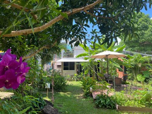 a garden with a house and an umbrella and flowers at Beach Jungle in Ko Chang