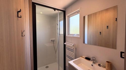 a bathroom with a shower and a sink and a mirror at Camping Les Palmiers in Hyères