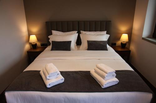 a bedroom with a large bed with towels on it at Monastiri Mountain Escape in Konitsa