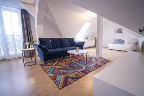 a living room with a blue couch and a rug at Apartmány Harmony Liptov - City Center & Private Wellness in Liptovský Mikuláš