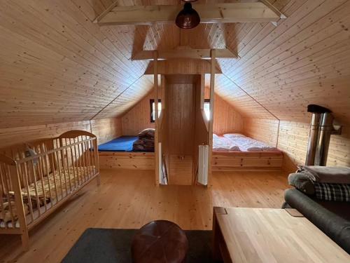 an attic room with a bed and a crib at Chata Mína in Smržovka
