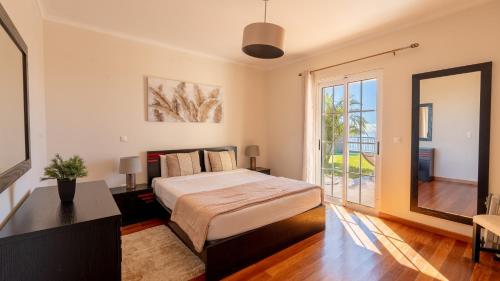 a bedroom with a bed and a large window at Casa Del Sol by LovelyStay in Relógio do Poiso
