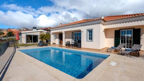 a swimming pool in front of a villa at Casa Del Sol by LovelyStay in Relógio do Poiso