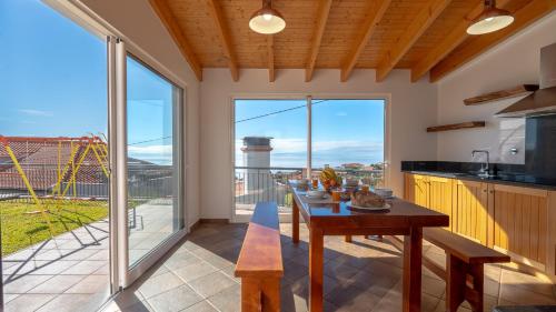 a kitchen with a table and a large window at Casa Del Sol by LovelyStay in Relógio do Poiso