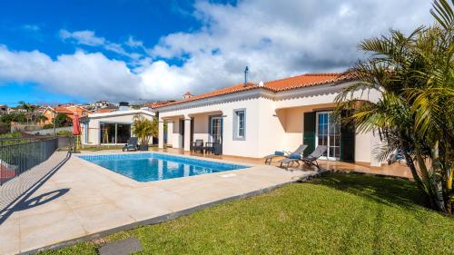 a villa with a swimming pool and a house at Casa Del Sol by LovelyStay in Relógio do Poiso