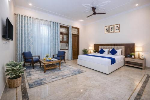 a bedroom with a bed and a table and chairs at Hotel Warm Welcome Inn Noida Sector 51 in Noida