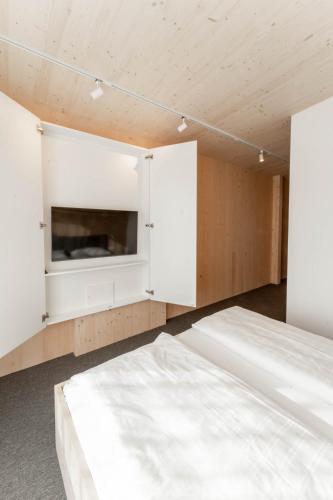 ein Schlafzimmer mit zwei Betten und einem Fernseher in der Unterkunft Karlingerhaus Hotel Hostel Home in Königswiesen