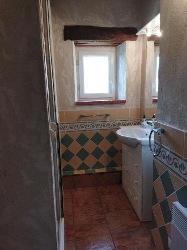 a small bathroom with a sink and a window at Gîte Le Provençal in Vagnas