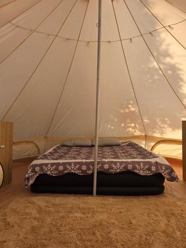 a bed in a tent with a blanket in it at KNM Living Home in Pai
