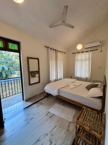 a bedroom with a large bed and a window at Nivrritii 3BHK Villa with hill and forest views in Canacona
