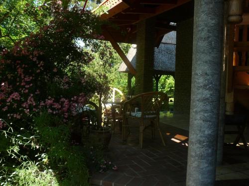 a patio with a table and chairs and flowers at Porkoláb Apartmanház in Gyenesdiás