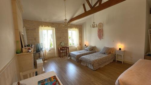 a living room with two beds and a television at ENTRE PIERRE ET BOIS in Saint-Savinien