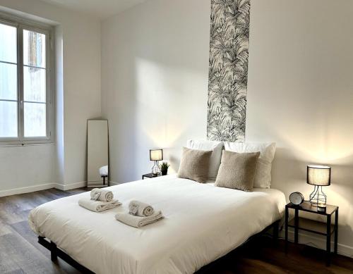 a bedroom with a large white bed with towels on it at LE WLÉRICK LUMINEUX - Spacieux - Hyper Centre in Mont-de-Marsan