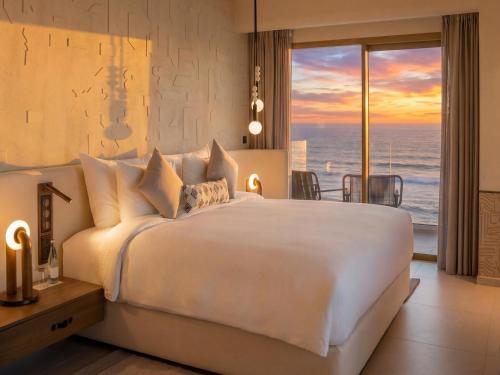 a bedroom with a large bed with a view of the ocean at STORY Le Carrousel Rabat in Rabat