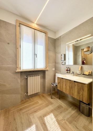 a bathroom with a large sink and a mirror at Valcamonica Apartments - Lake in Boario Terme