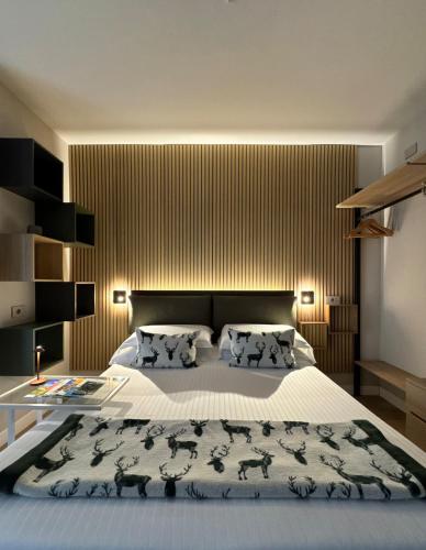 a bedroom with a large bed and a wooden wall at Valcamonica Apartments - Lake in Boario Terme