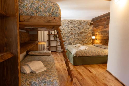 a bedroom with two bunk beds and a staircase at Visaisa taverna & foresteria in Acceglio