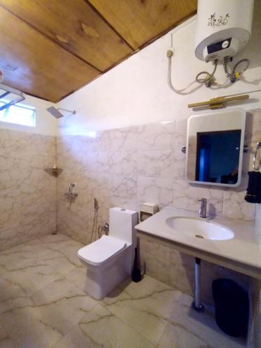 a bathroom with a white toilet and a sink at Meis cottage Umpling in Shillong