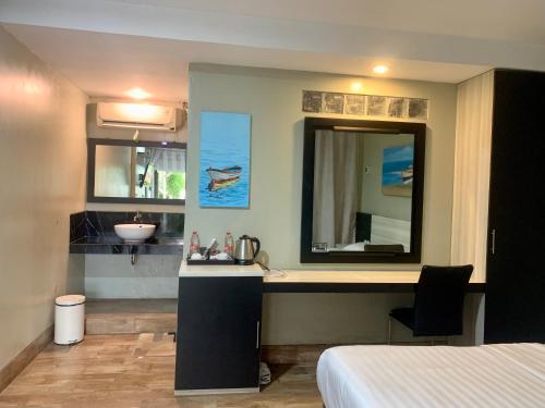 a bathroom with a sink and a mirror at Wisma Lovebird in Kalianget