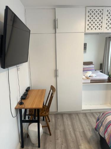 a room with a table and a tv on a wall at Standard Double Room near OVO Wembley Stadium in London