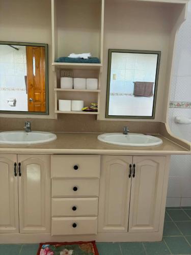 a bathroom with two sinks and a mirror at Pableo's Pension House in Moalboal in Moalboal