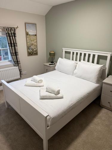 a bedroom with a white bed with towels on it at The Mary Arden Inn in Stratford-upon-Avon