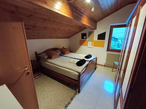 a bedroom with a bed in a room with wooden ceilings at Casa del Capitano Hilton in Isolaccia