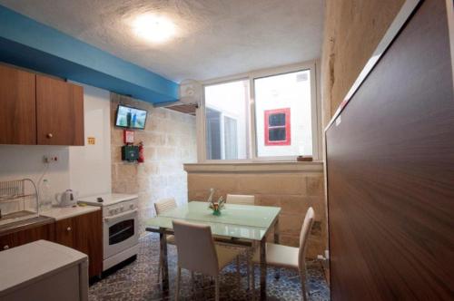 uma pequena cozinha com uma mesa e uma janela em The 1930's Maltese Residence em St Paul's Bay